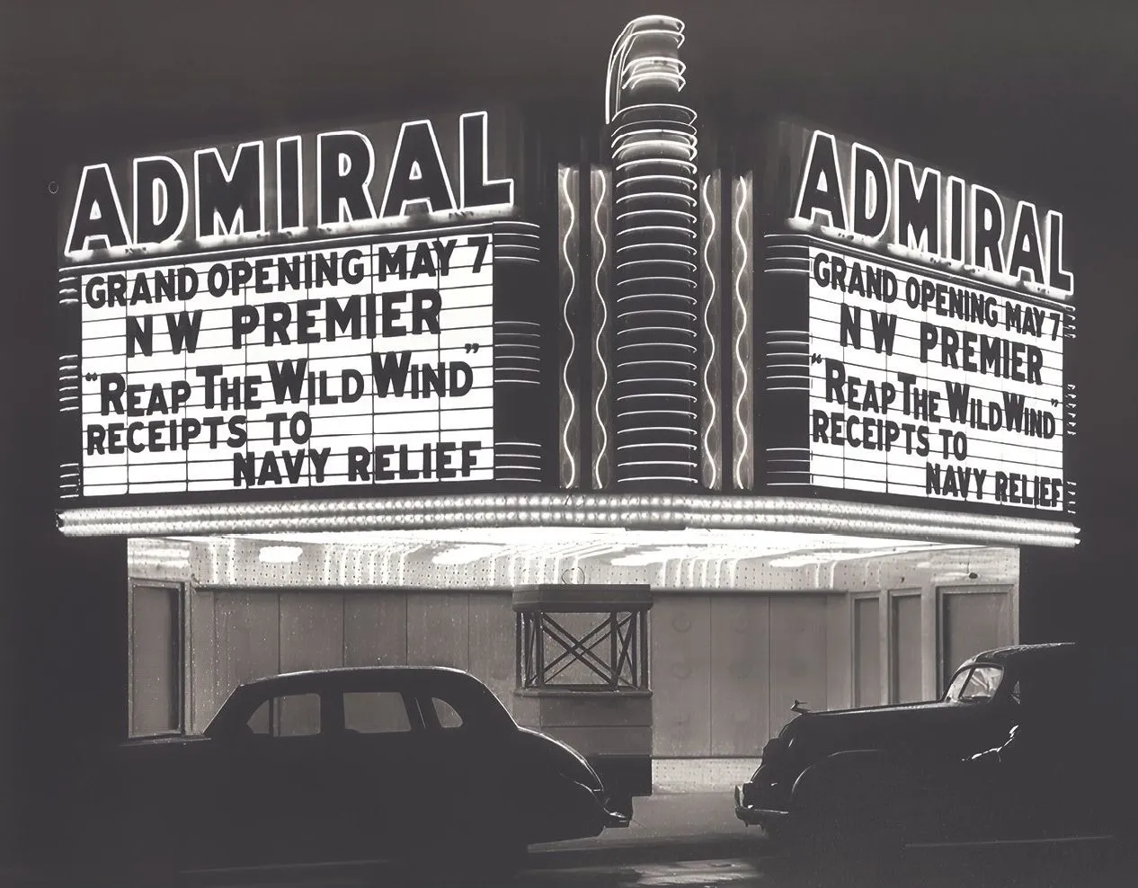 The Admiral Theatre's marquee at night on its 1942 opening, announcing the Northwest premiere of Reap the Wild Wind with receipts to Navy Relief.